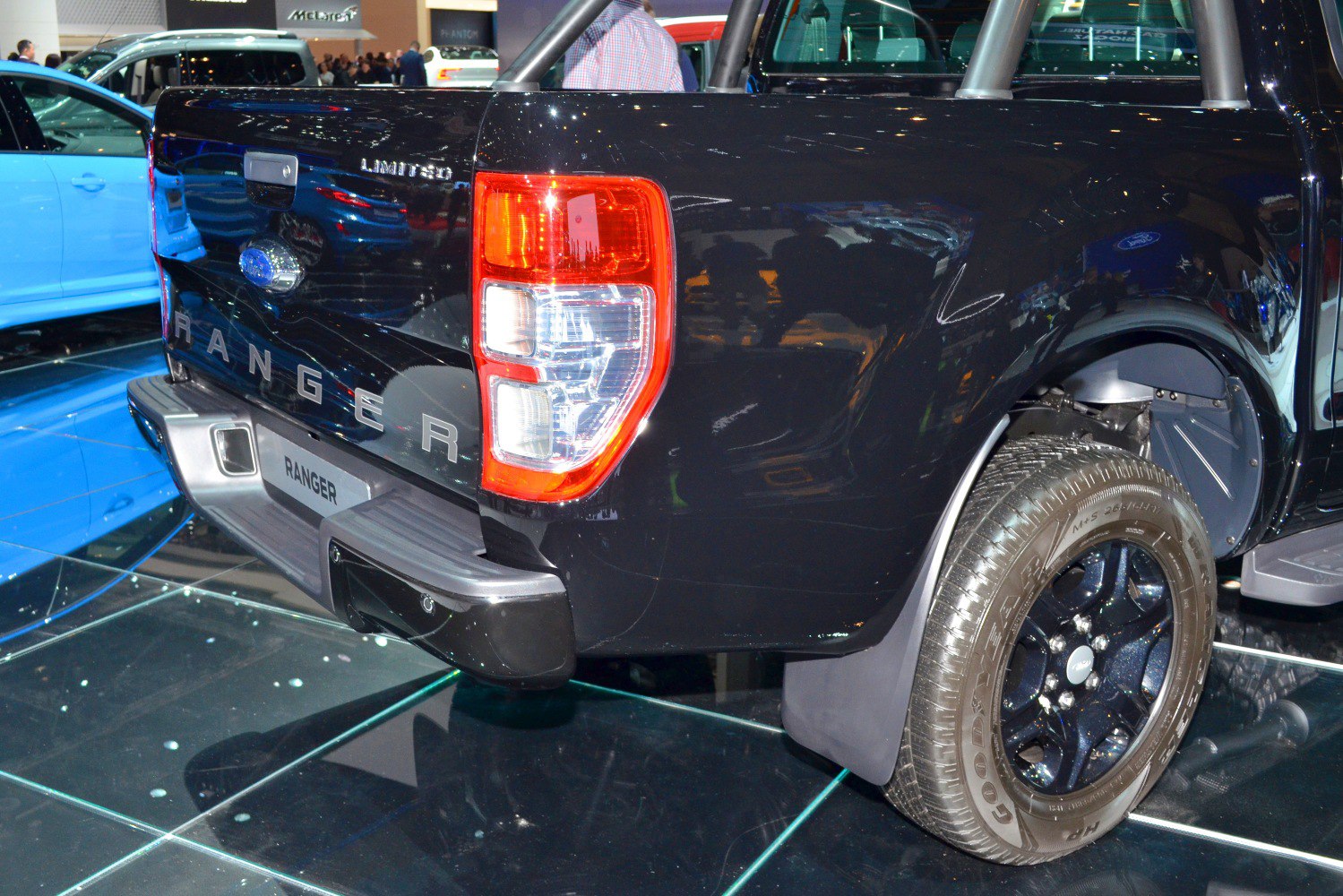 Rear tailgate with taillight and rear wheel of black pickup truck