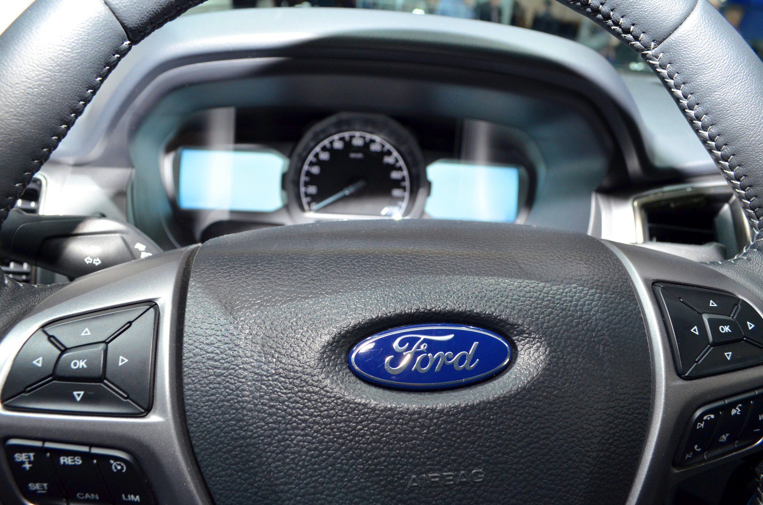 Steering wheel with control buttons and analog instrument cluster
