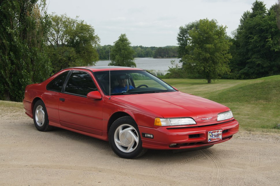 Red two-door coupe with sleek front 3-4 view and classic design.