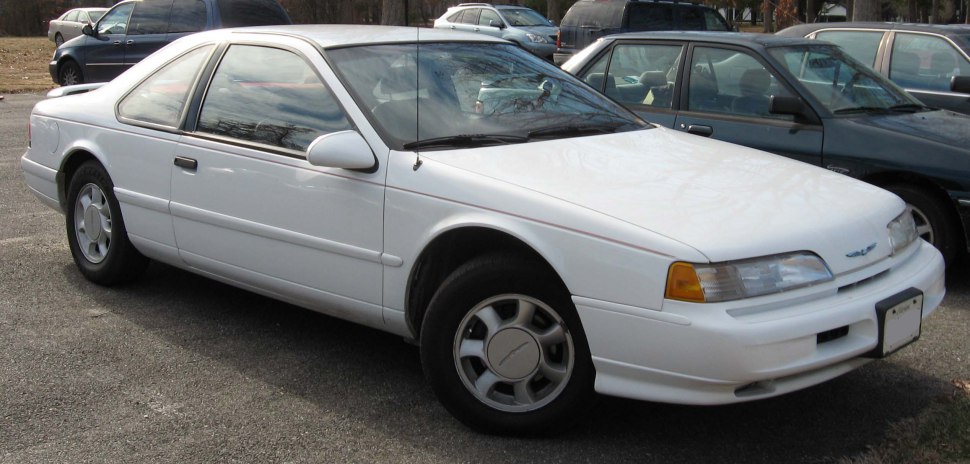 White two-door coupe with aerodynamic body and classic 90s styling.