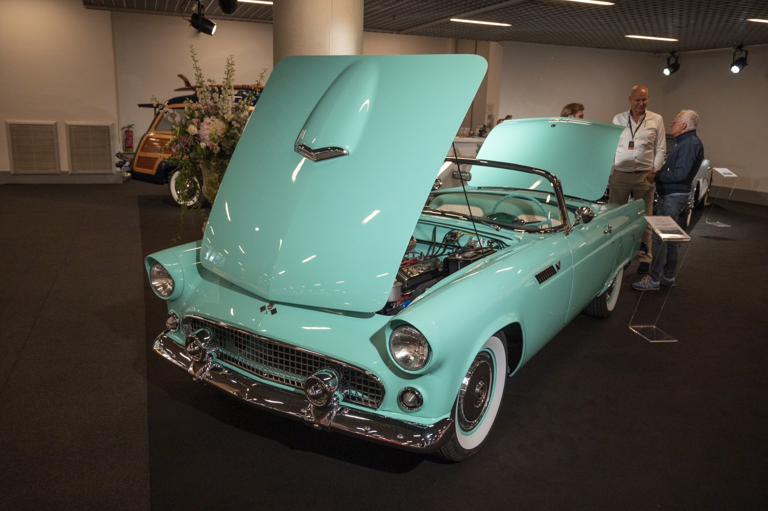 Convertible with open hood showing engine and classic front grille with chrome
