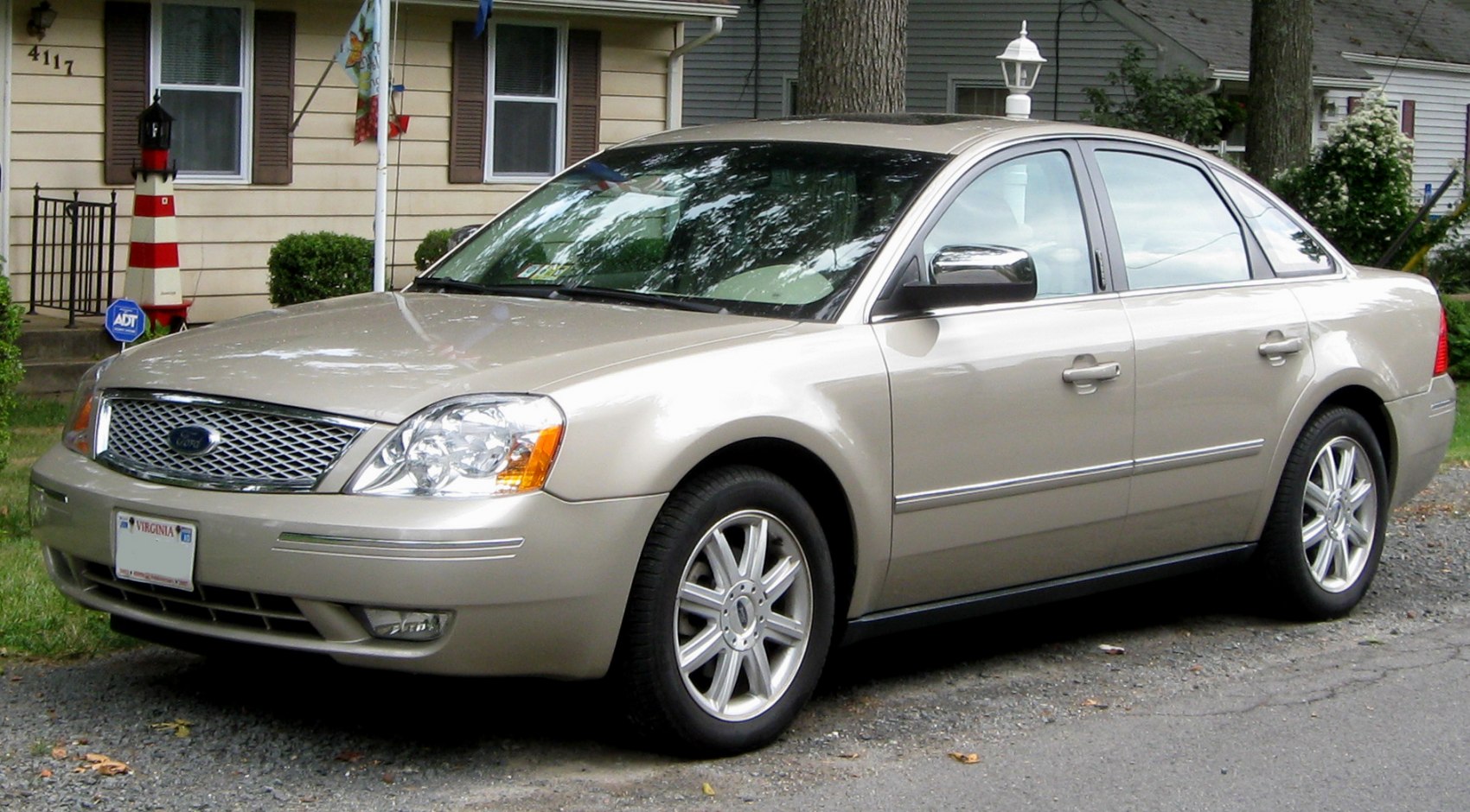 Front side view of silver beige sedan with chrome grille and alloy wheels