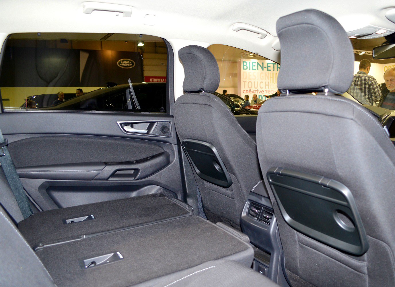 Folded rear seats with back seat trays in a vehicle interior
