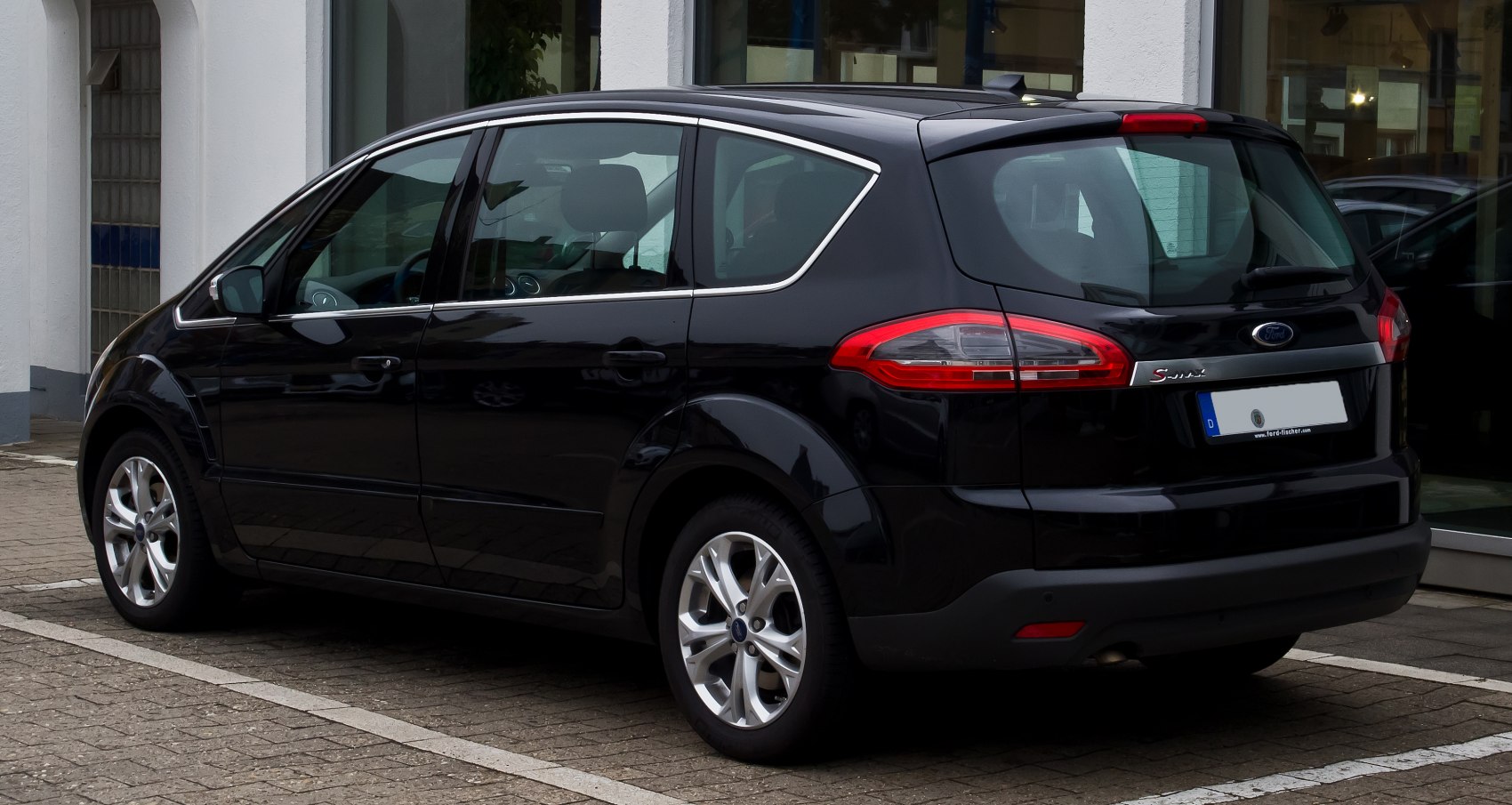 Rear side view of a black MPV with distinctive taillights and alloy wheels