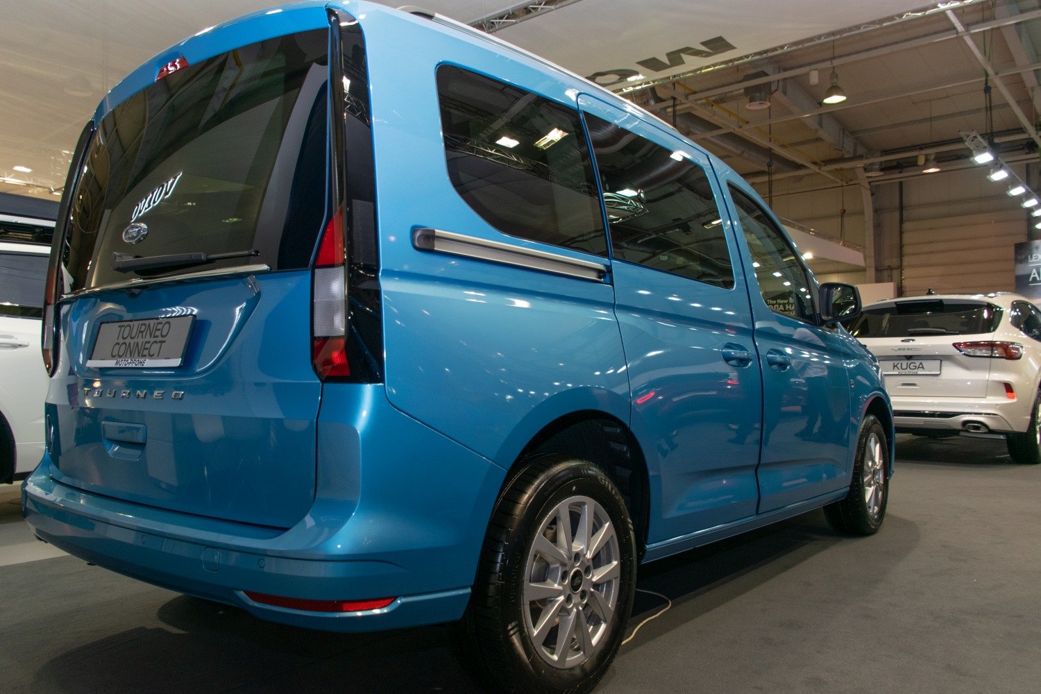 Rear and side view of a blue minivan with sliding door and vertical taillights