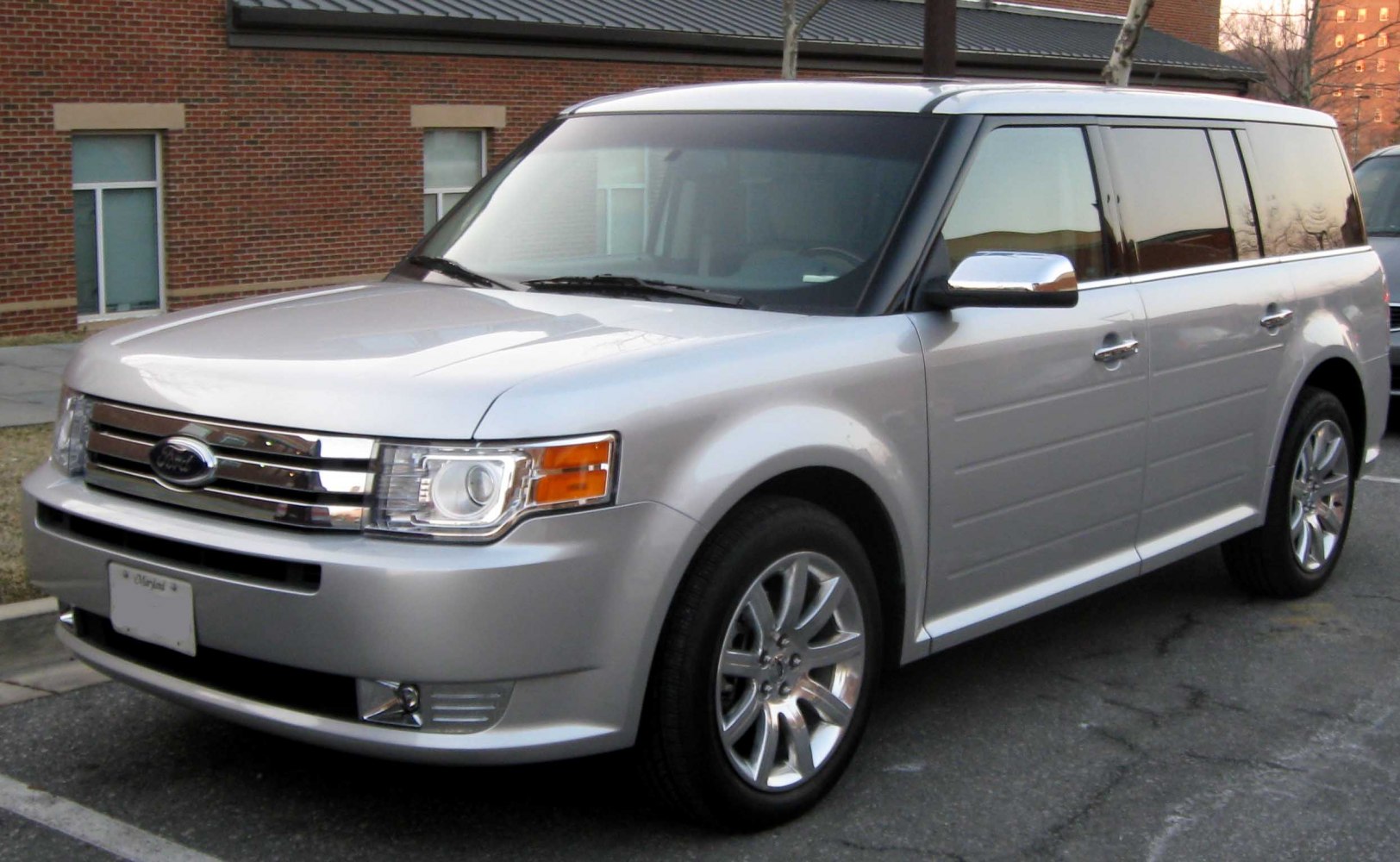 Distinctive chrome grille, projector headlights, alloy wheels on boxy vehicle