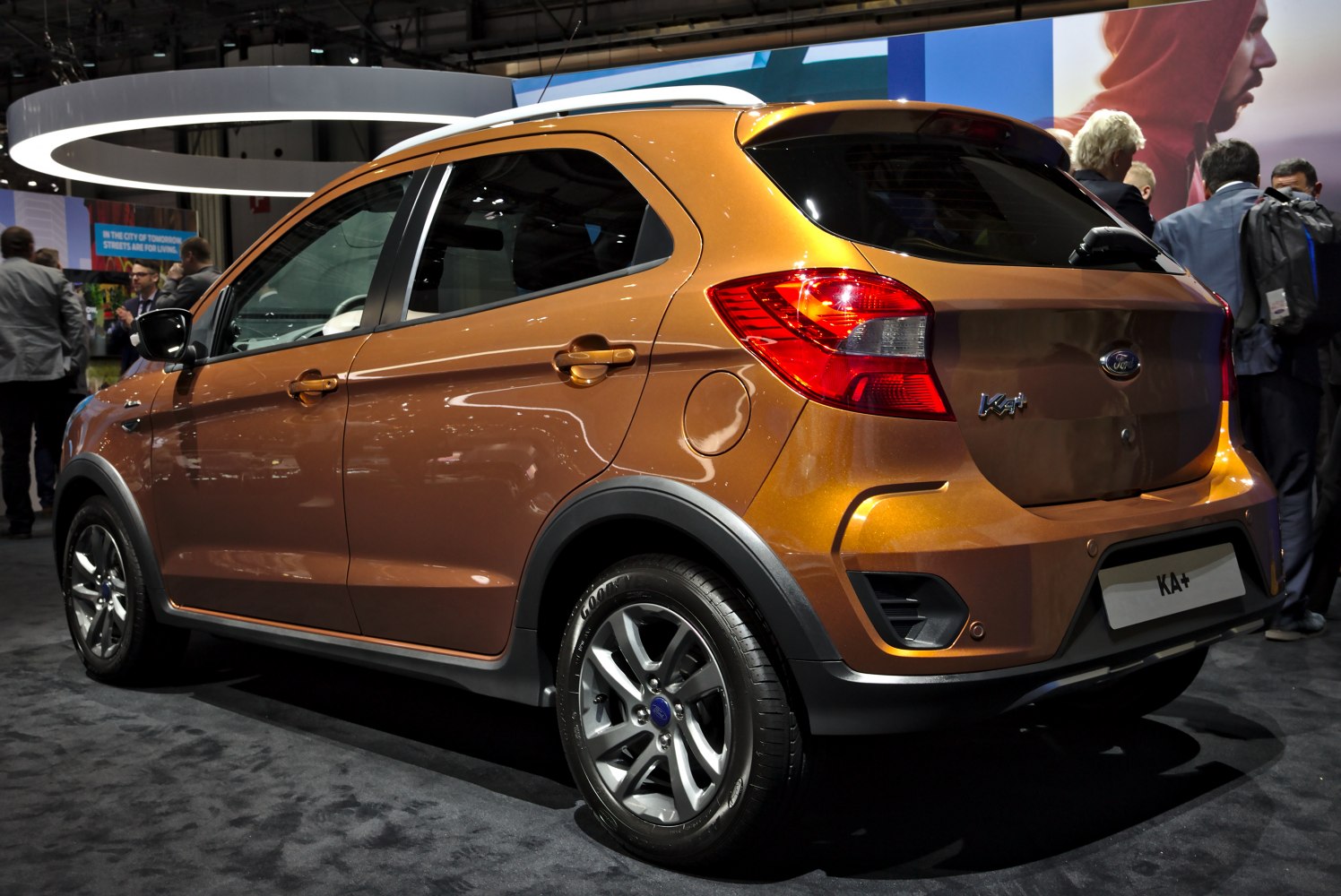 Rear side view of compact crossover with alloy wheels and rear spoiler
