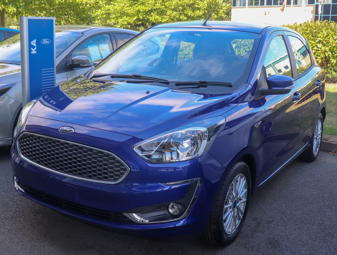 Front close-up of blue hatchback showing hexagonal grille and sleek headlights