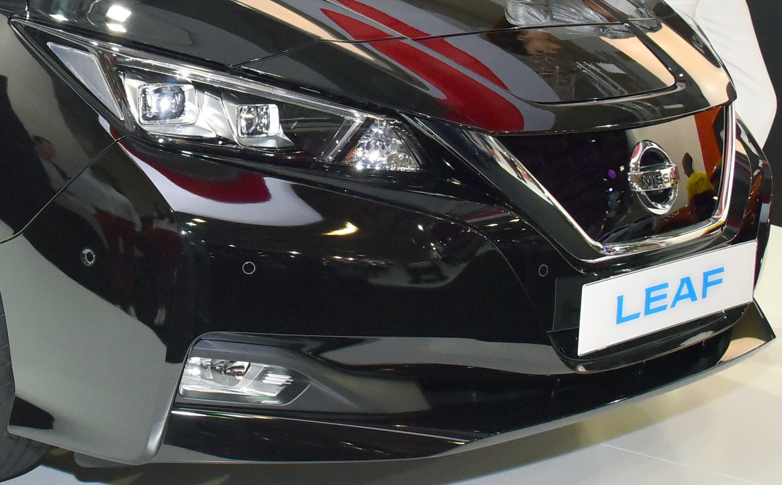 Front headlight, grille and bumper details of a black modern electric vehicle