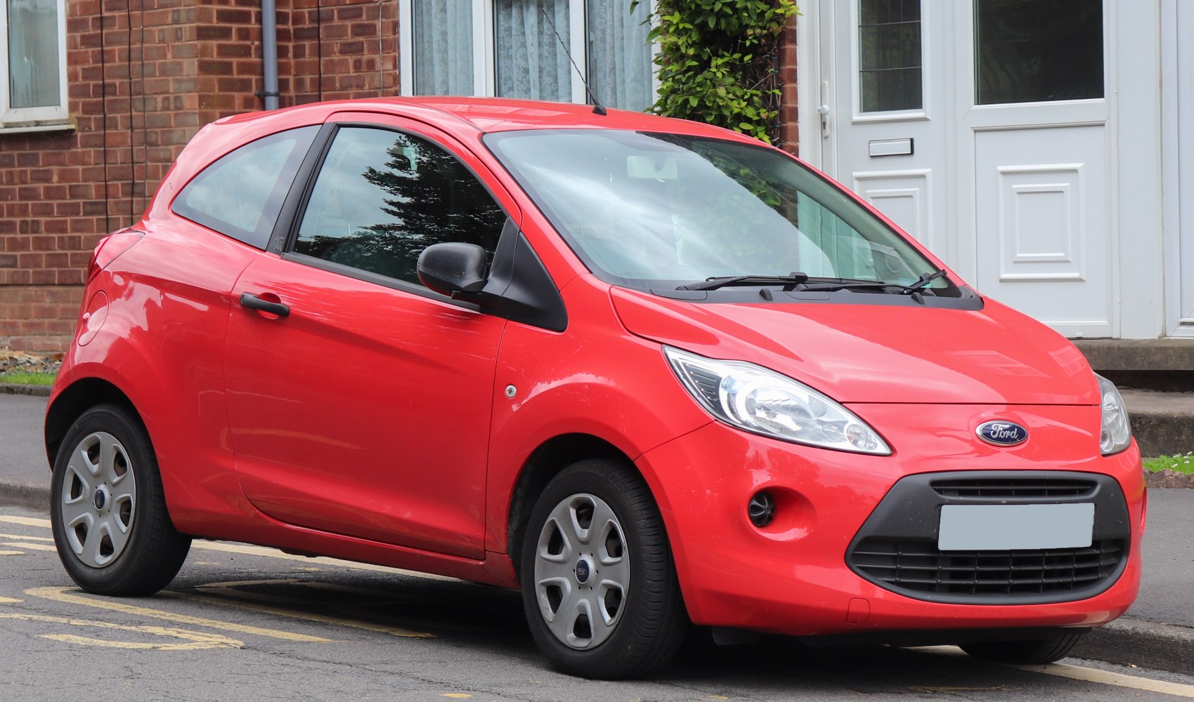 Red compact 3-door hatchback with distinct headlights and black grille