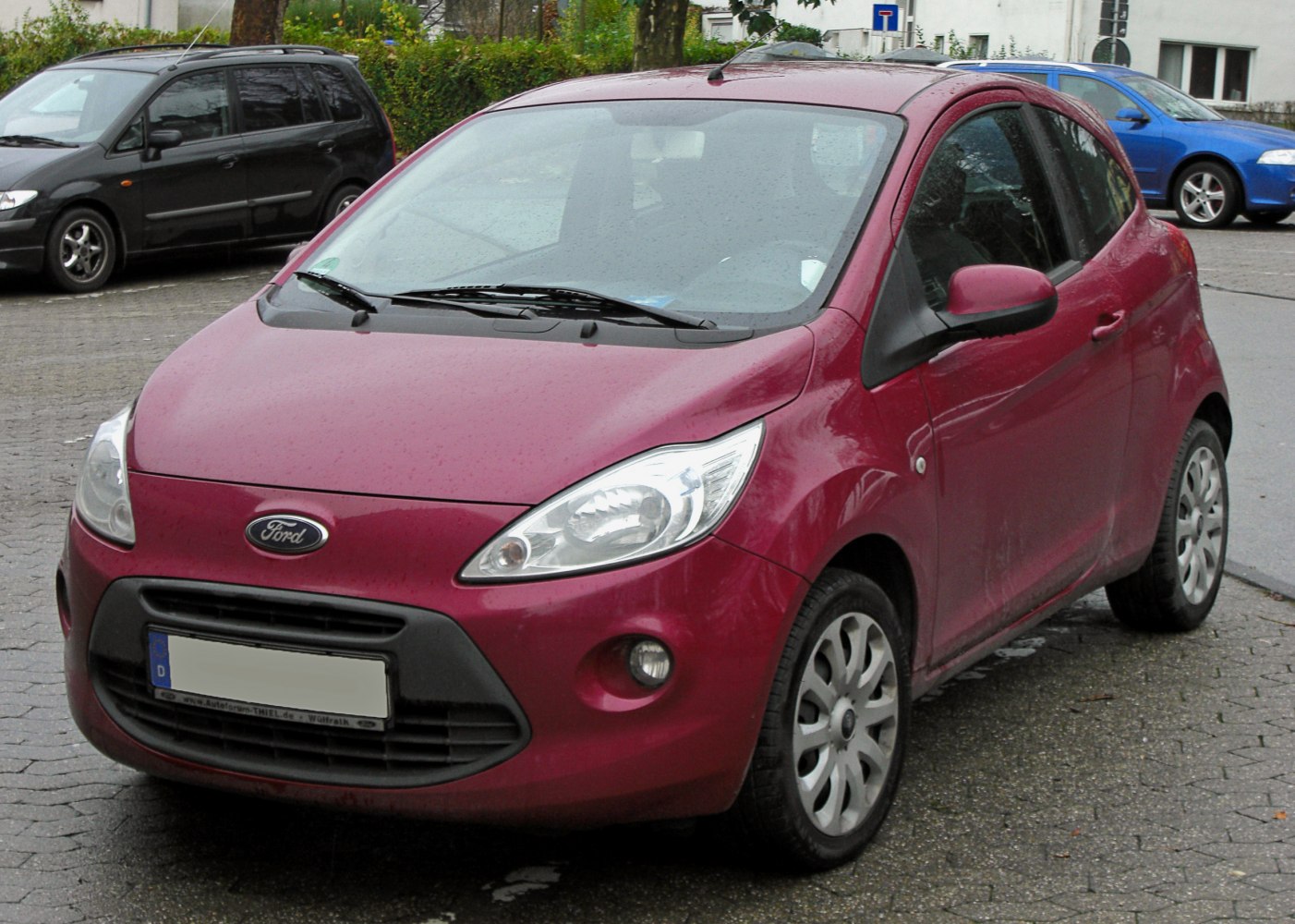 Front view of a red 3-door compact hatchback with curved headlights