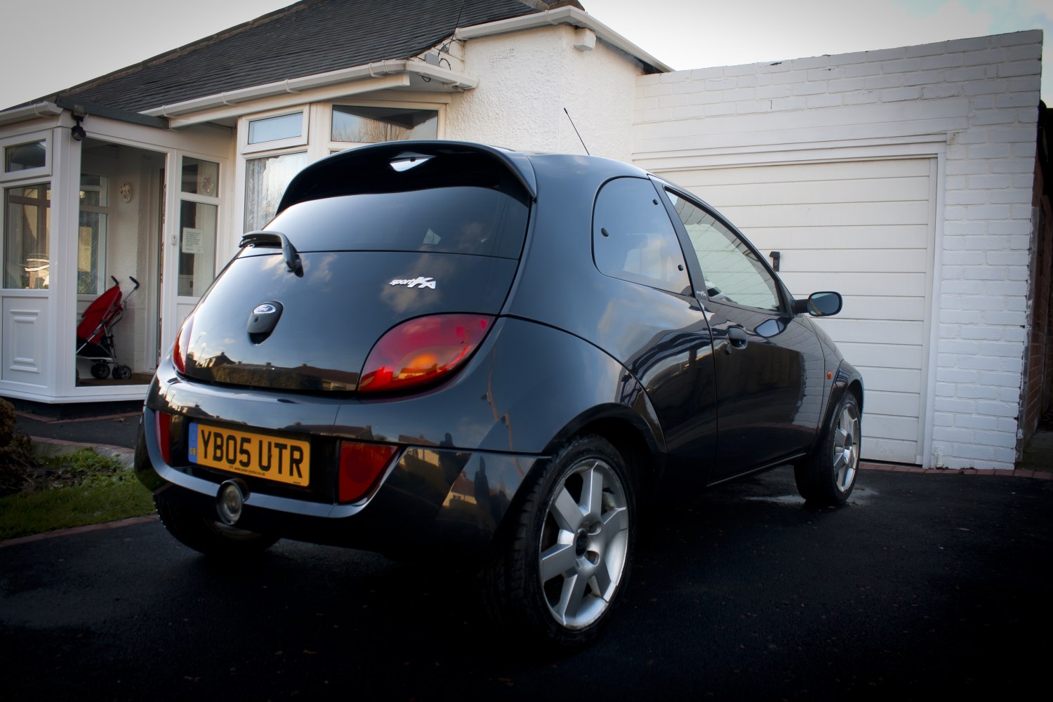 Rear and side view of a compact hatchback with spoiler and tinted windows