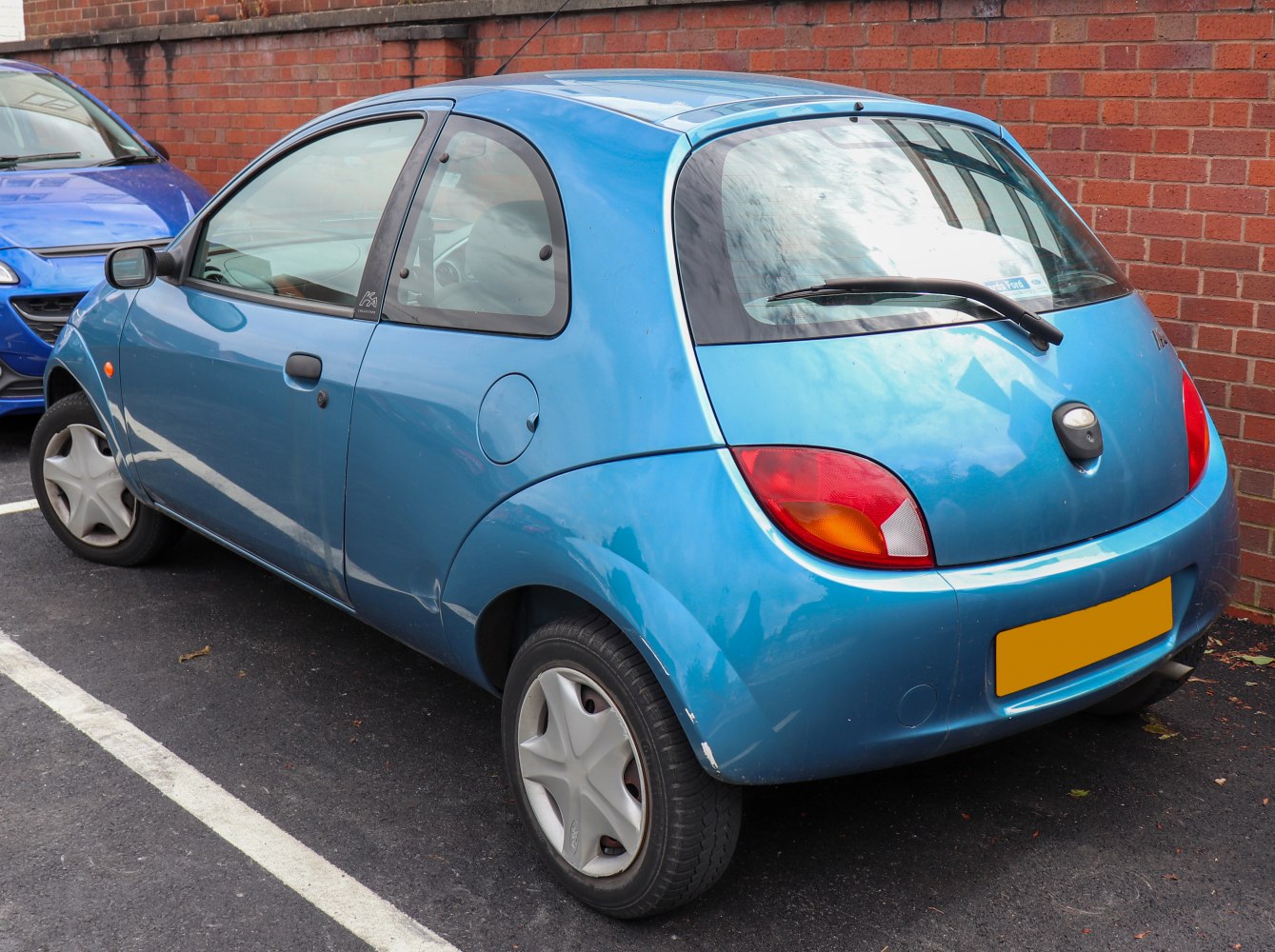 Compact rounded hatchback rear with distinctive taillights and small wheels