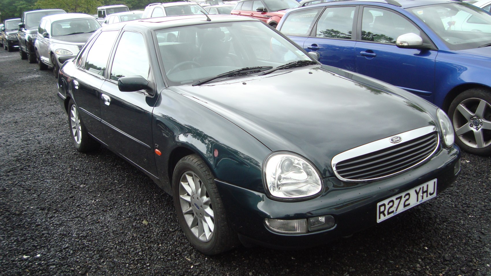 Oval headlights with chrome grille on a classic 90s sedan front view