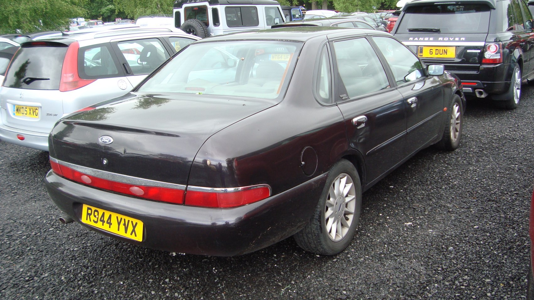 Rear view of a sedan with continuous rear light bar and alloy wheels