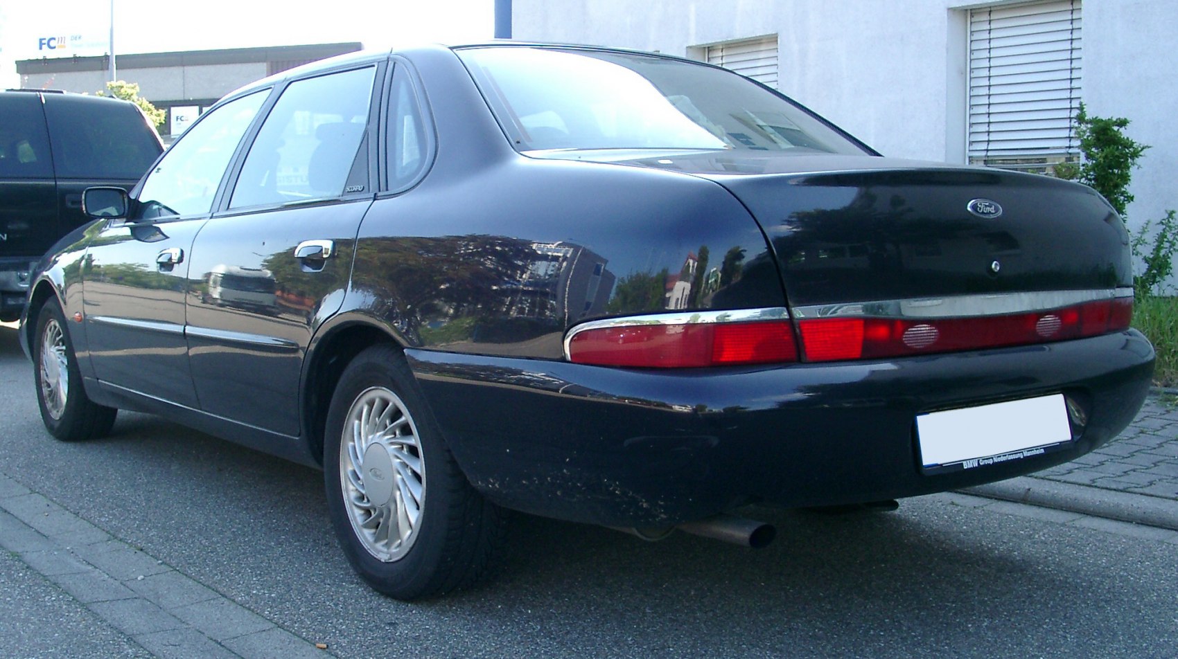 Rear side view of a sedan with classic tail lights and chrome trim