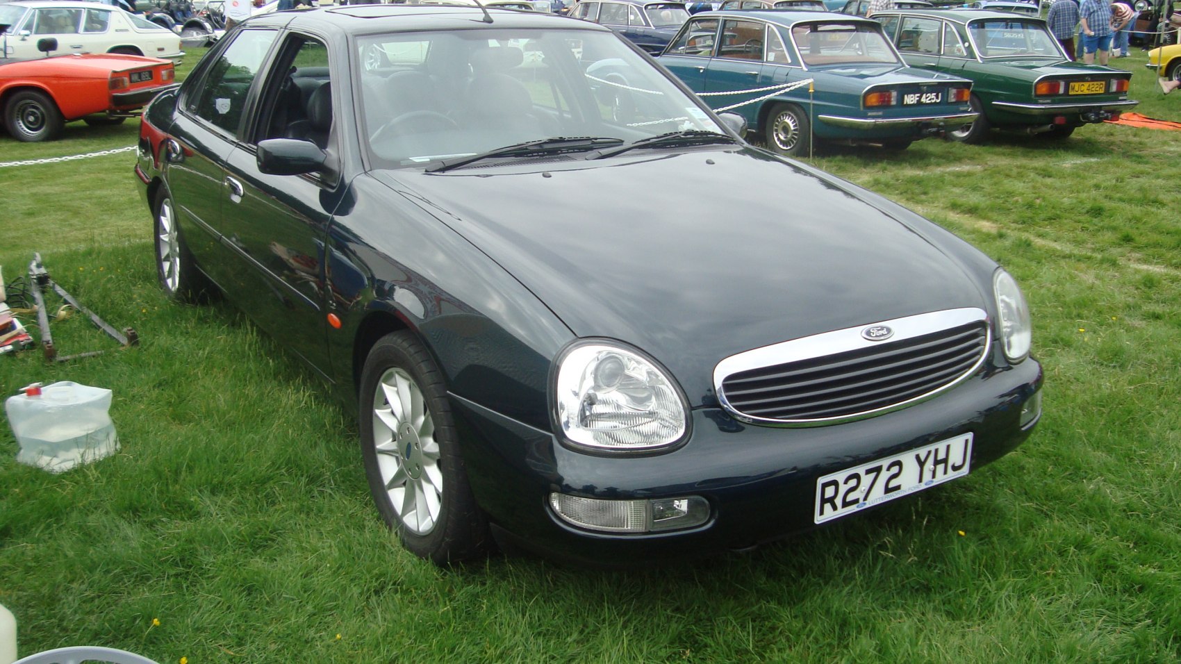 Front 3/4 view of a sedan with oval headlights and a chrome grille