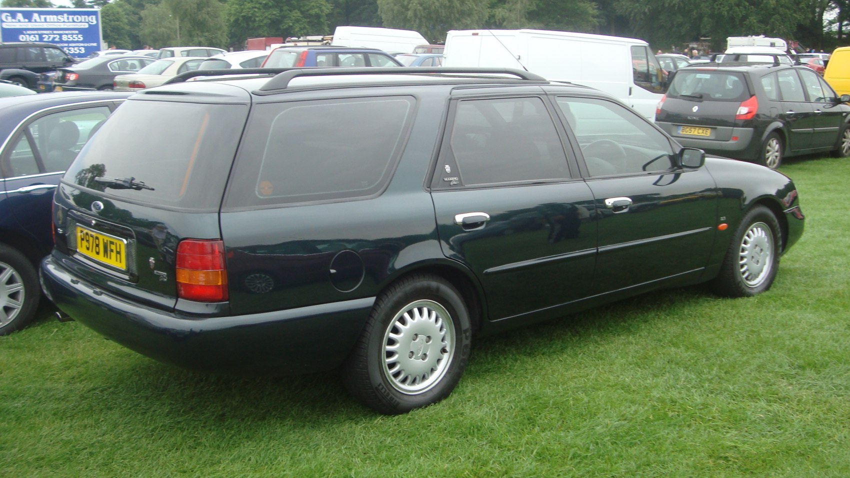Rear-side view of a mid-1990s station wagon with roof rails and alloy wheels