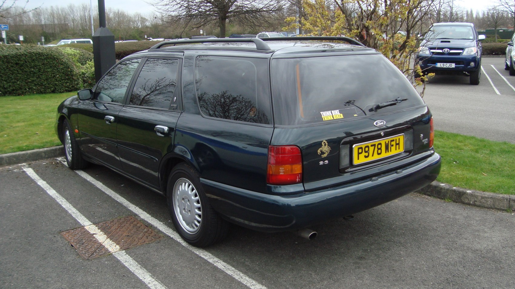 Rear and side view of a classic 1990s station wagon with roof rails and taillights