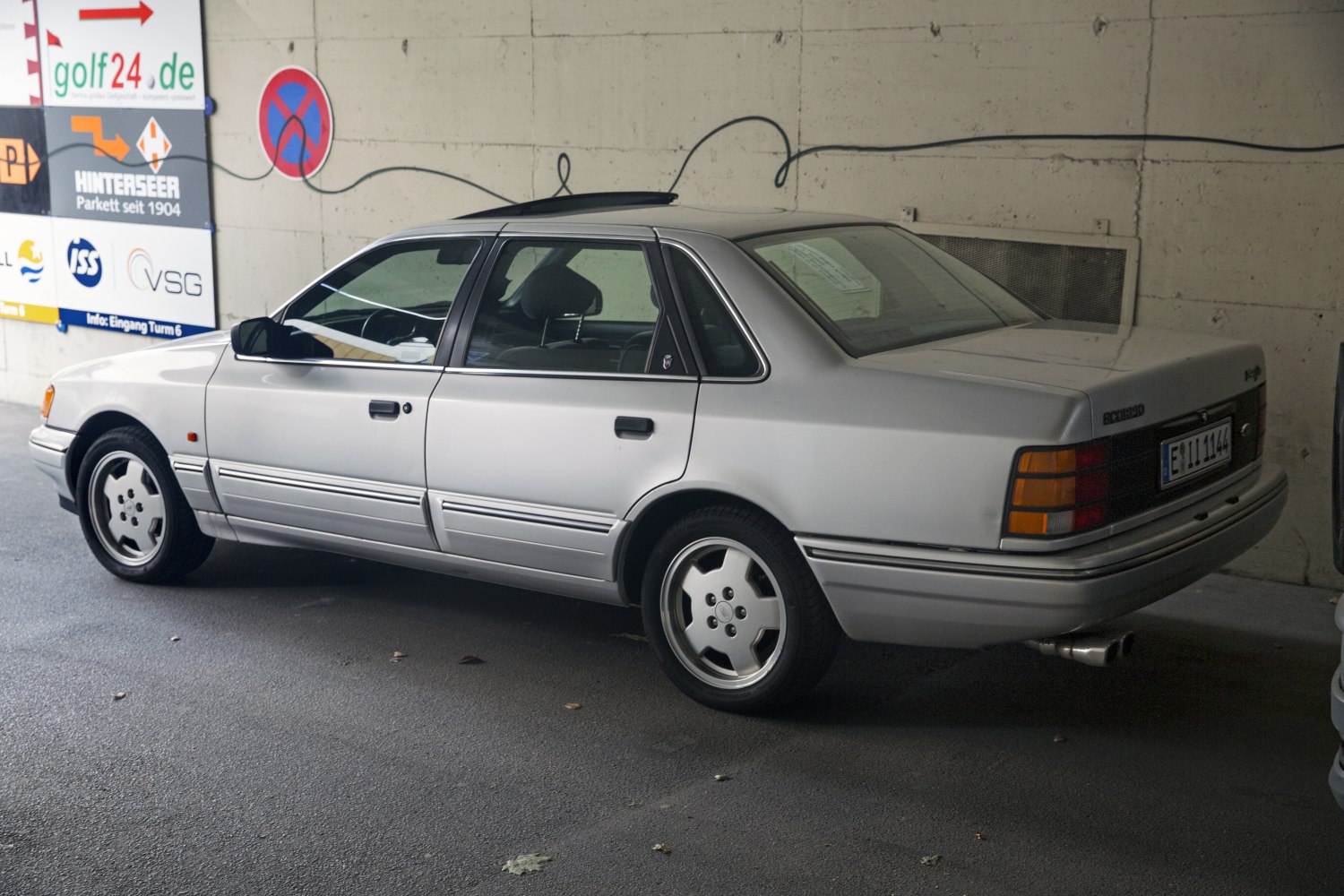 Rear side view of classic silver sedan with distinctive taillights