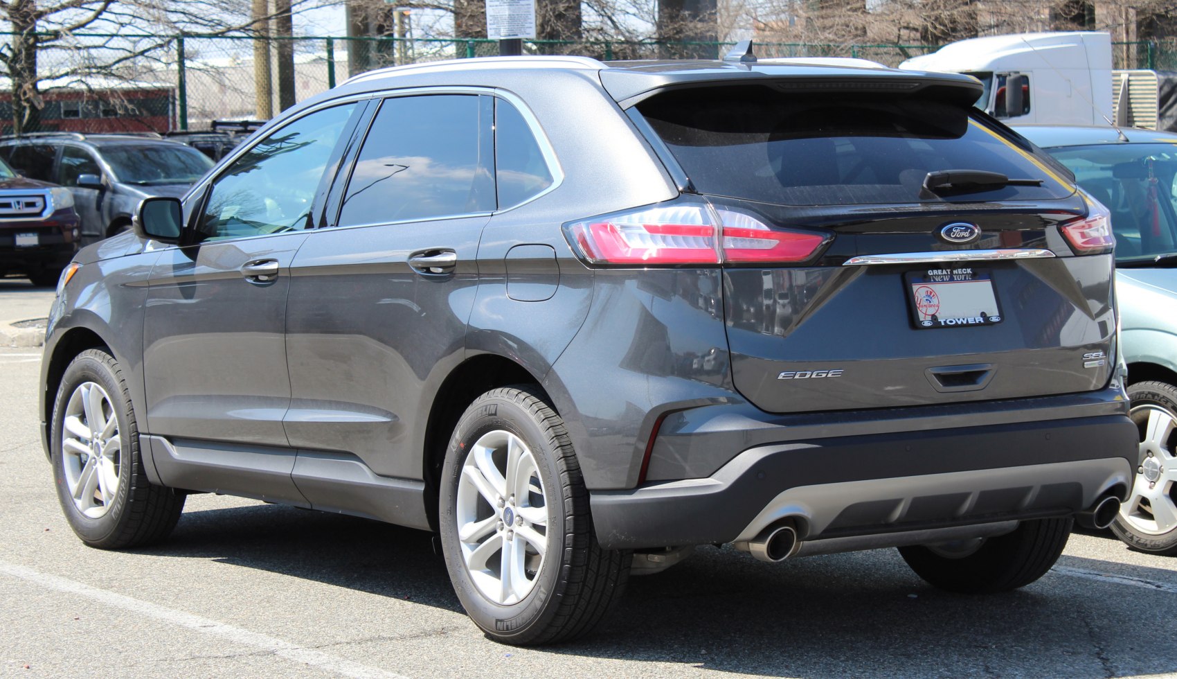 Rear side profile of a midsize SUV with dual exhaust and sleek tail lights