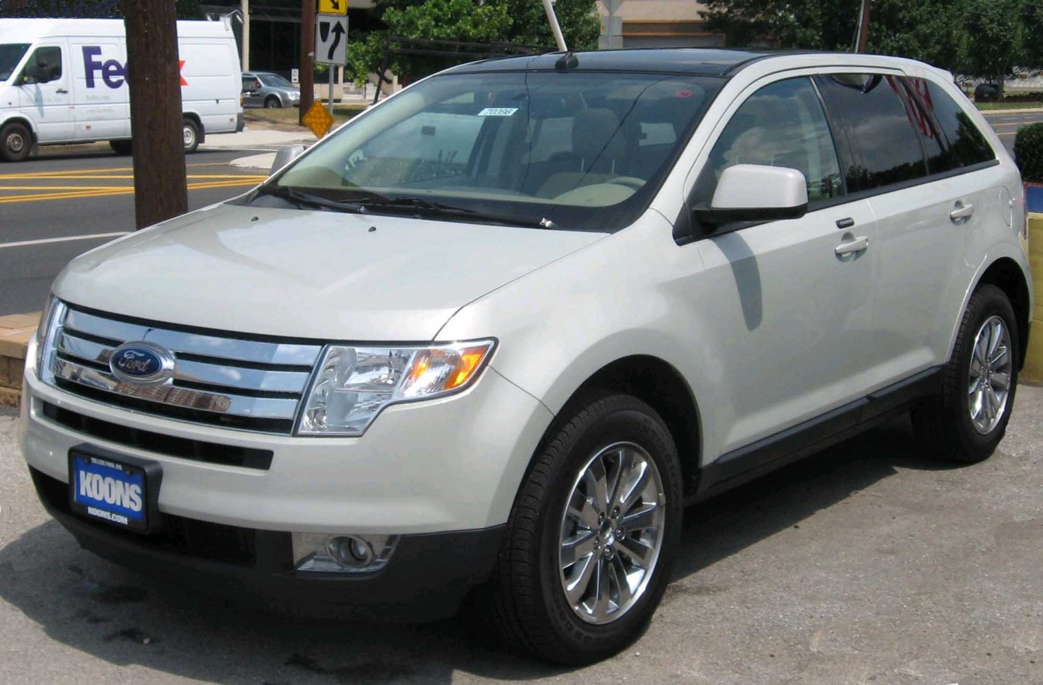 Front three-quarter view of white mid-size SUV with chrome grille and alloy wheels