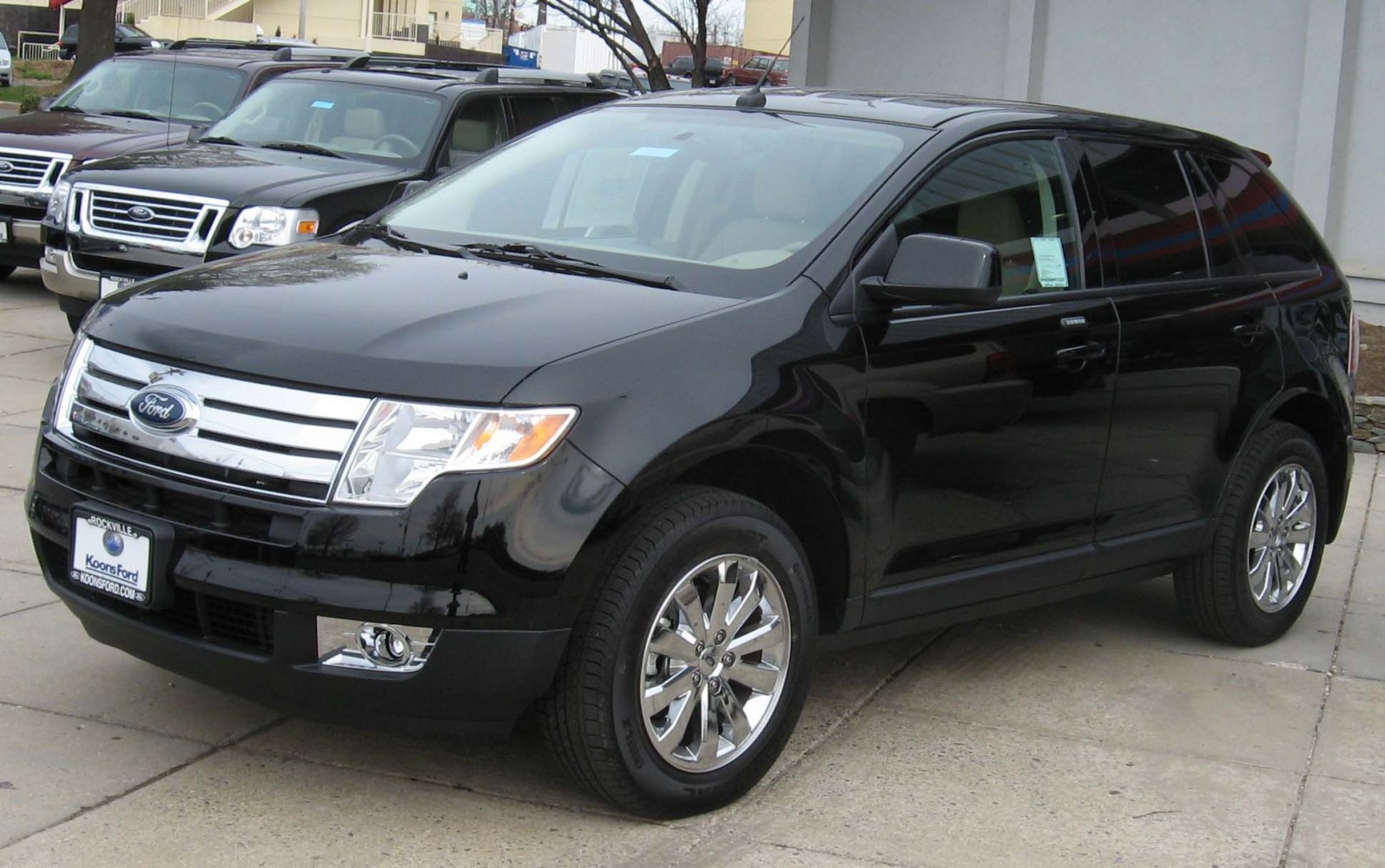 Black SUV with chrome grille and alloy wheels from front side.