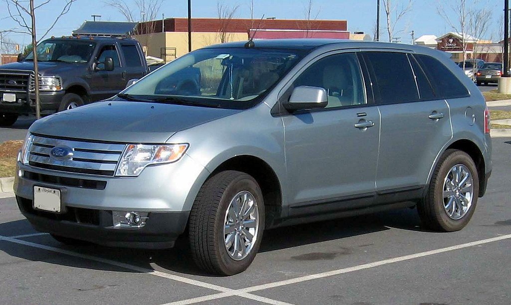 Silver midsize SUV front side view with chrome grille and alloy wheels