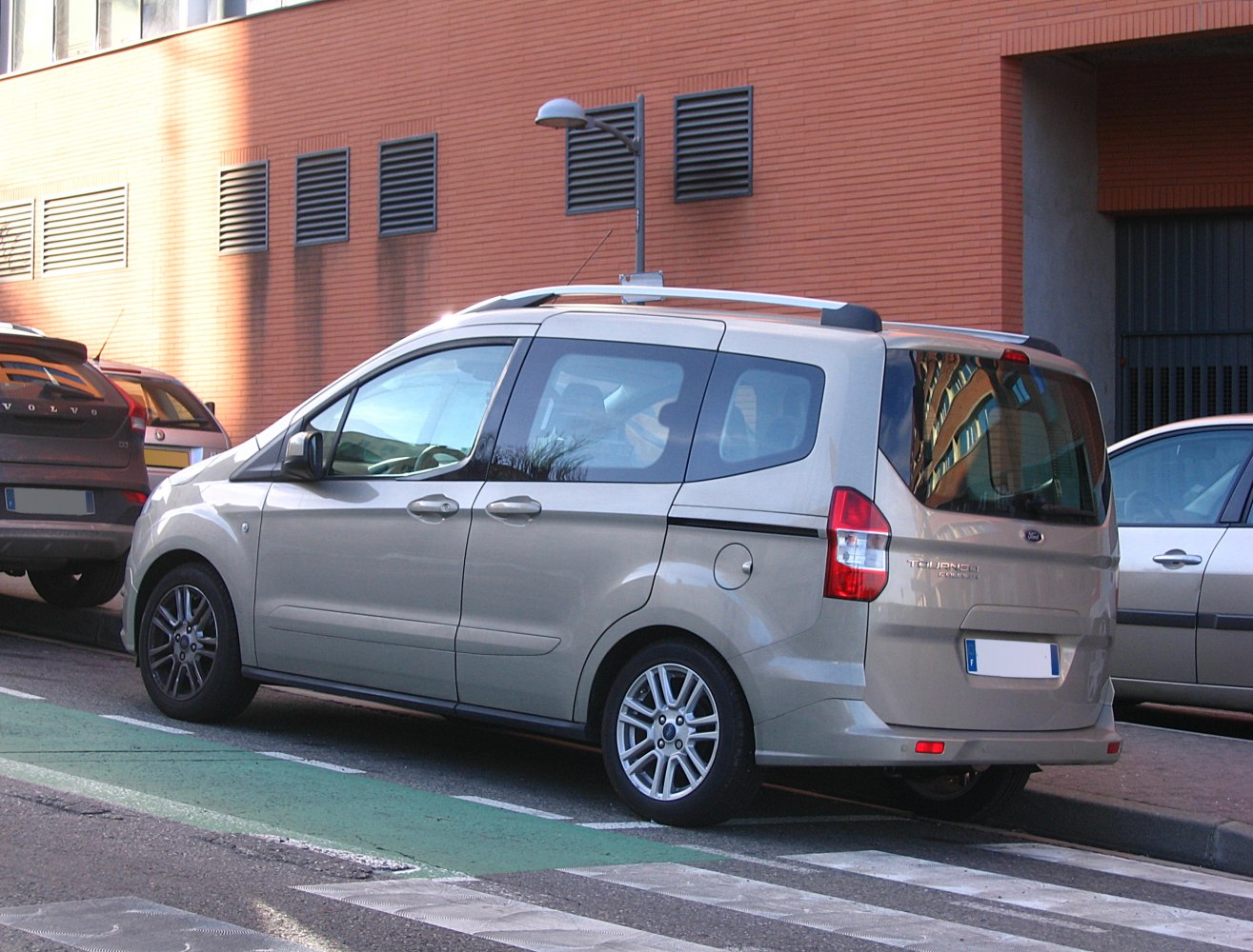 Rear side view of compact MPV with sliding door and roof rails