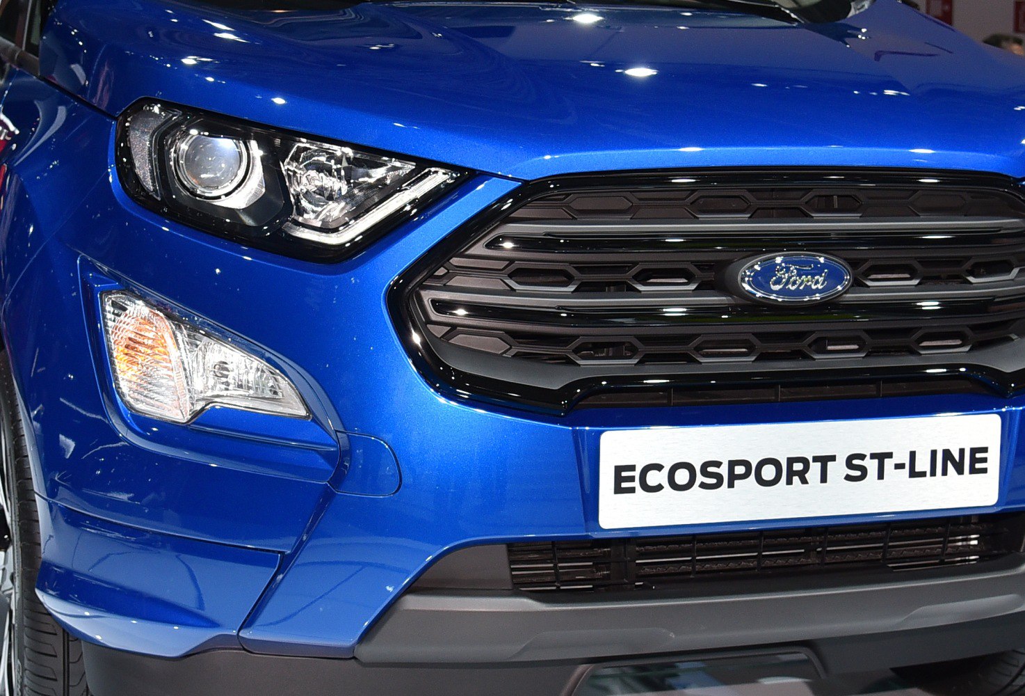 Close-up of front headlight and black honeycomb grille