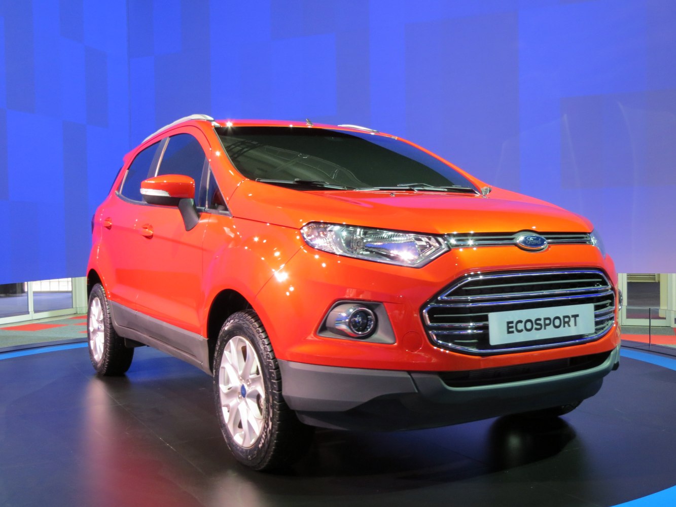 Bright orange compact SUV front with modern headlights and grille