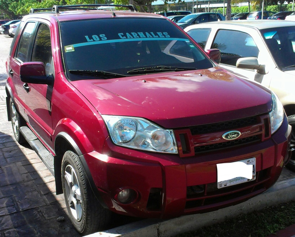 Red SUV front with distinctive headlights and grille