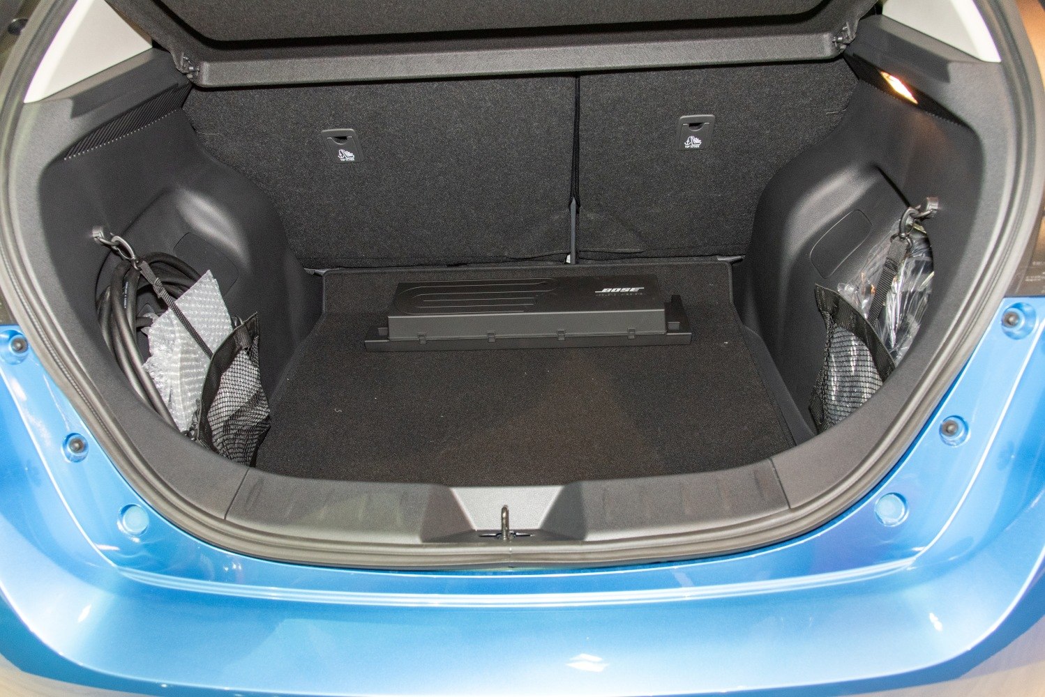 Spacious electric vehicle trunk with storage nets and audio system