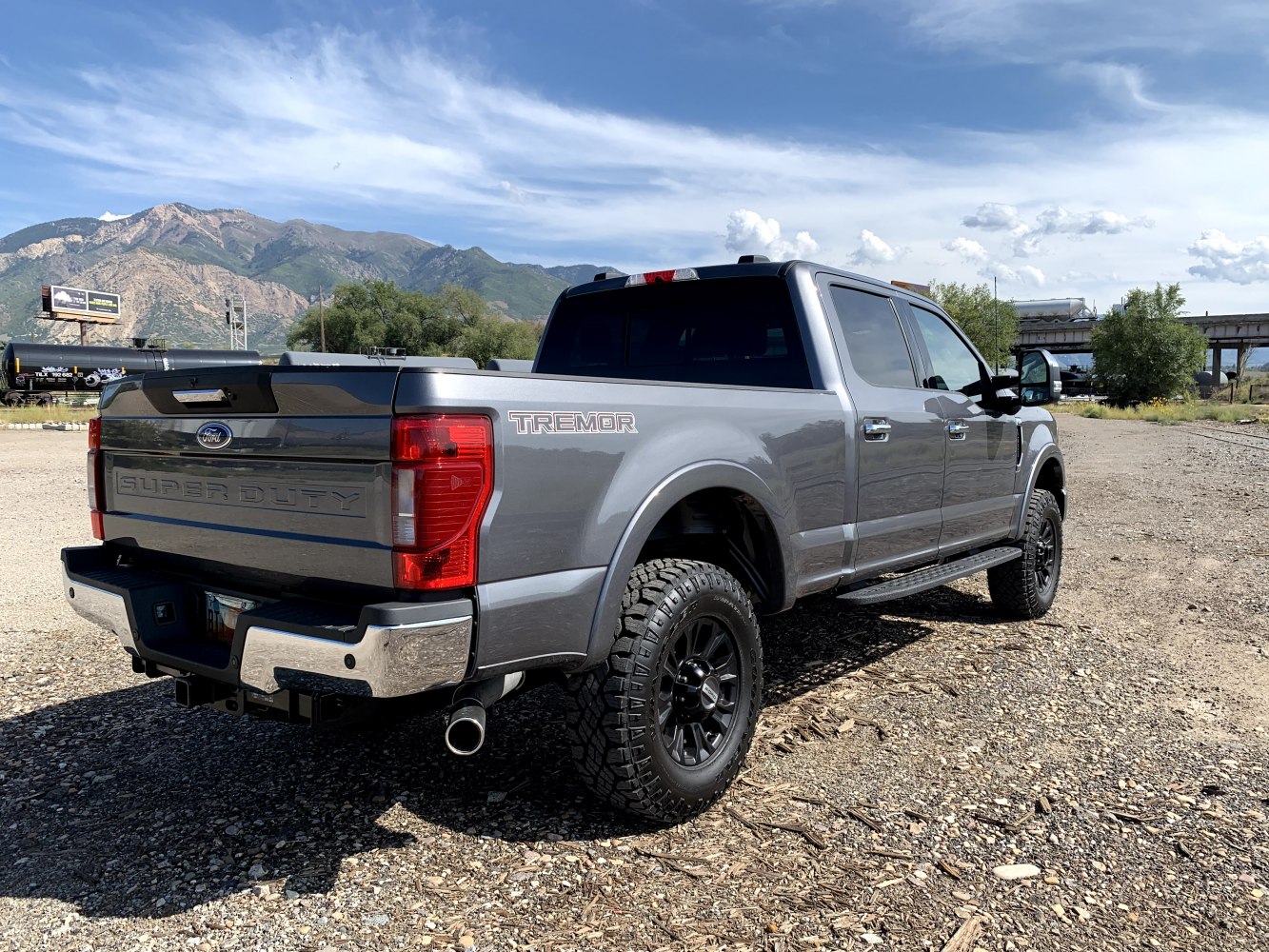 Rear view of a heavy-duty crew cab pickup with off-road tires and chrome bumper.