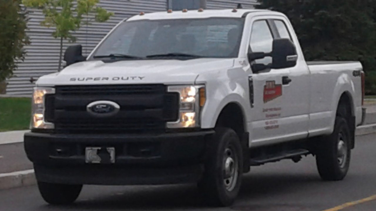 White heavy-duty pickup truck with super cab and long cargo bed