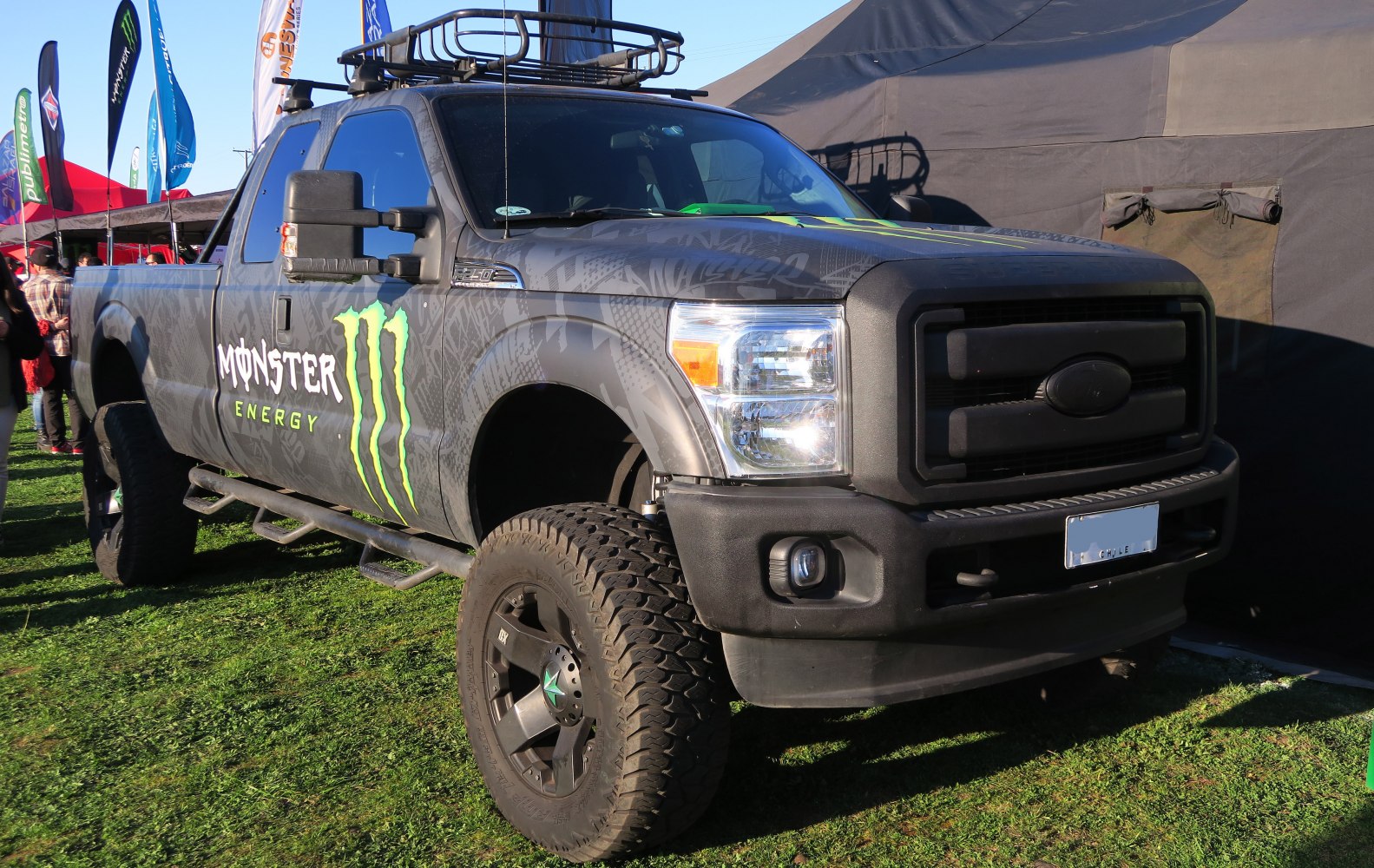 Lifted pickup with Monster Energy wrap and off-road tires