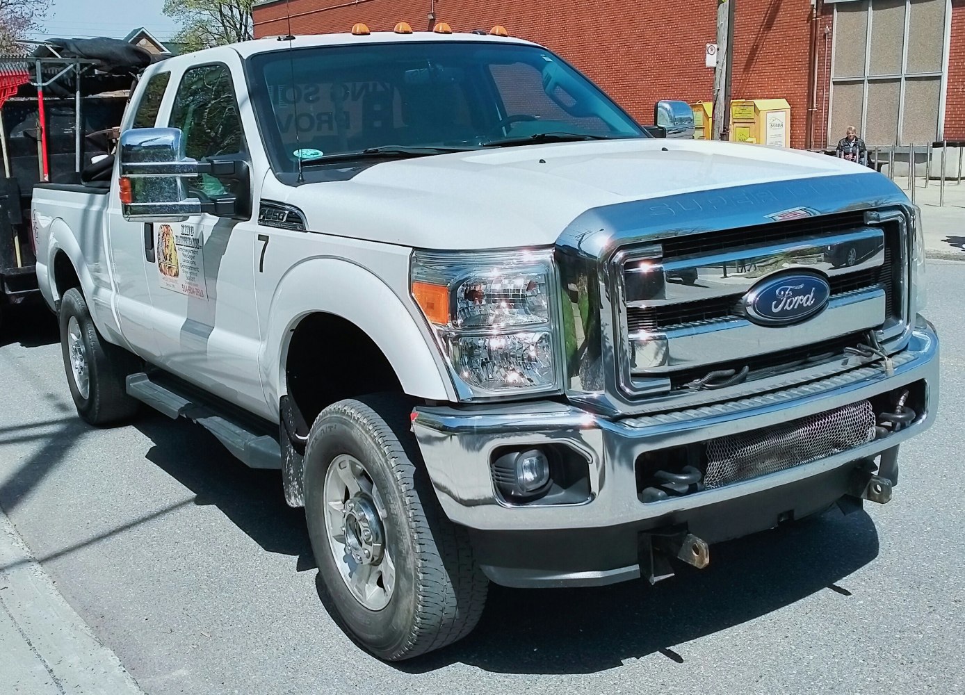 Heavy-duty pickup with chrome grille, super cab, short bed, amber roof lights