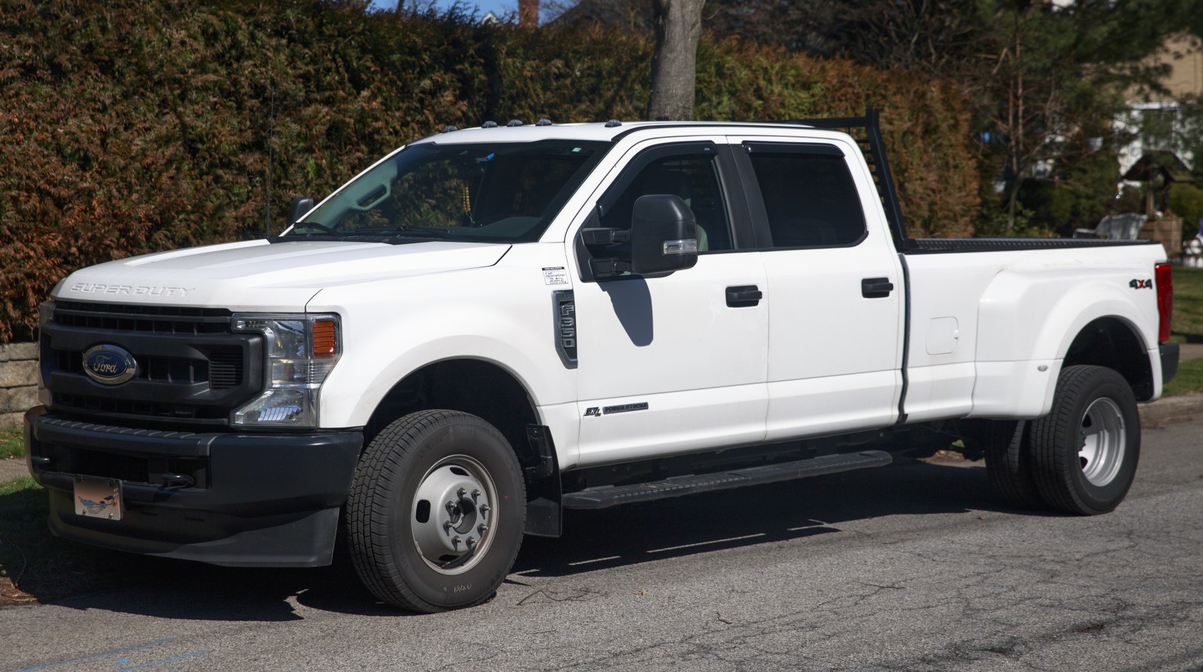 Front side view of a large white heavy duty pickup truck with dually rear wheels