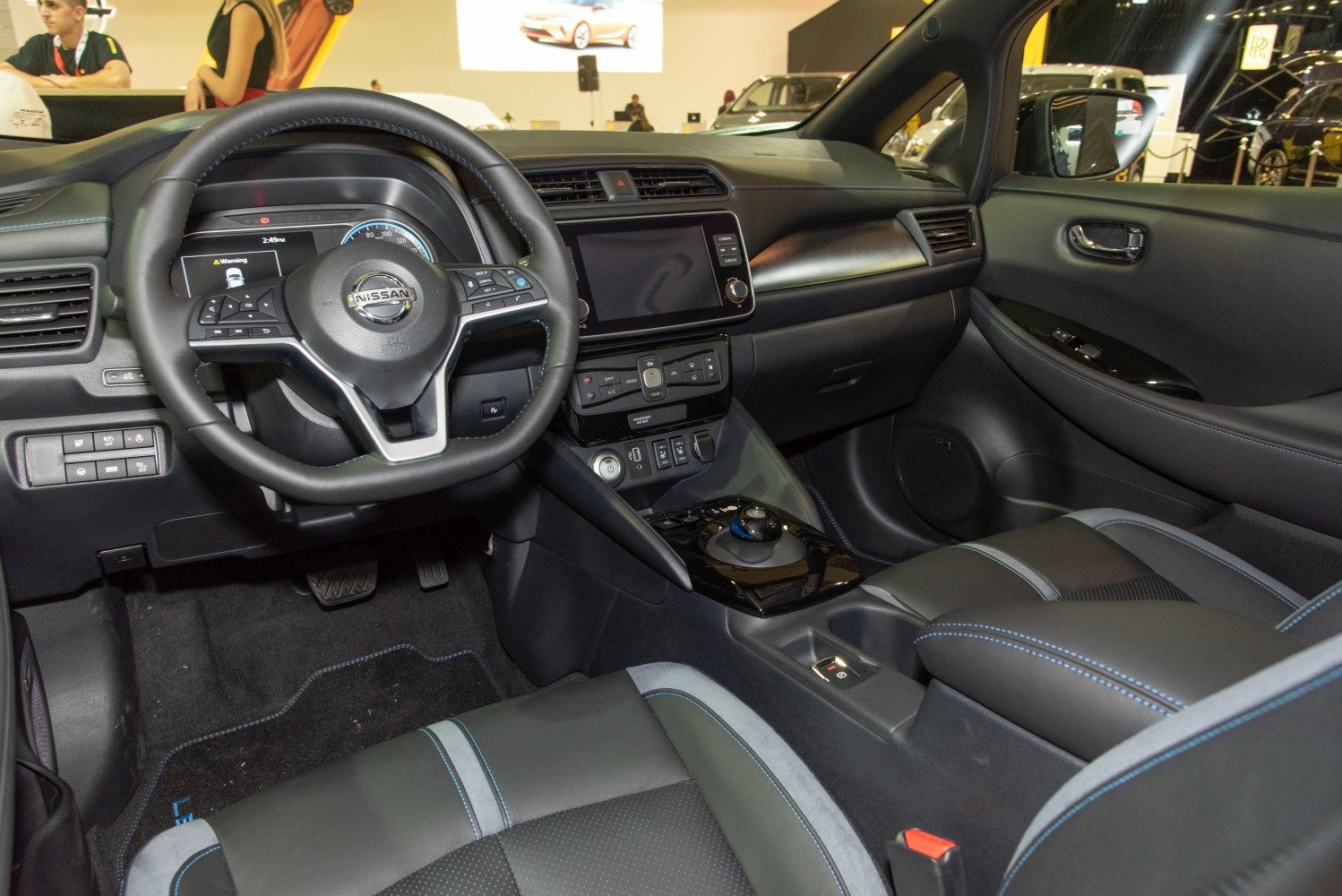 Dashboard, steering wheel, center console, and front seats of a modern electric vehicle.