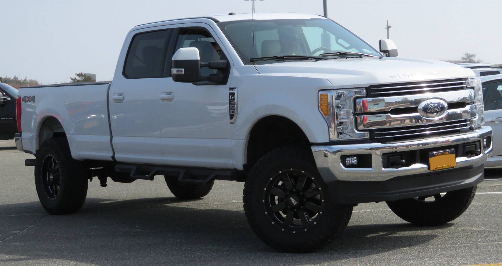 Heavy-duty pickup truck with crew cab, long bed, black rugged wheels