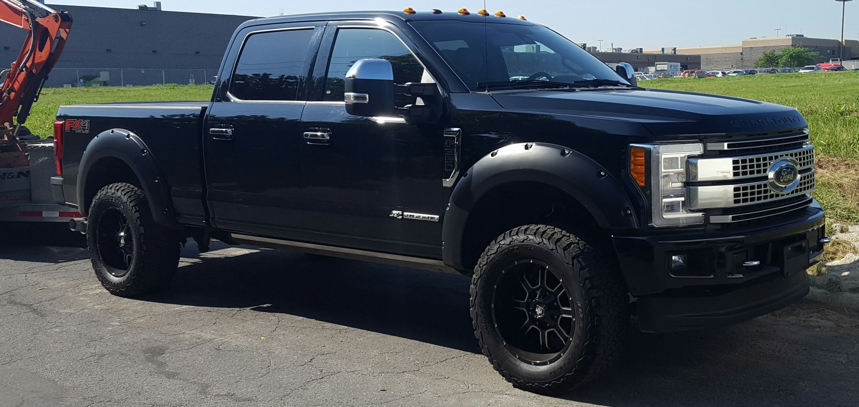 Black 2018 heavy-duty pickup with off-road tires and fender flares
