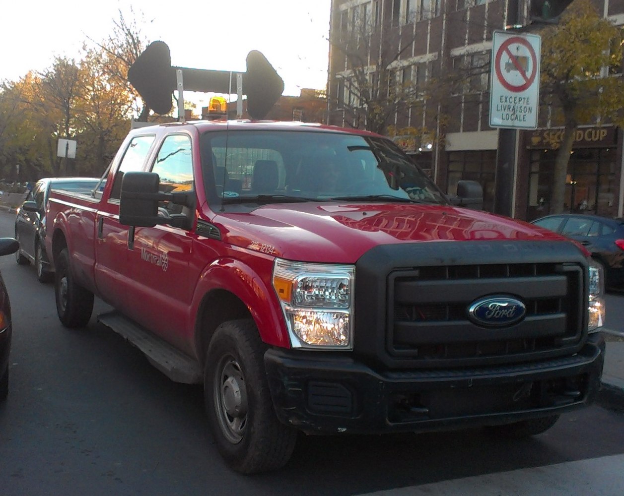 Red heavy-duty pickup with crew cab and long bed, equipped with utility light equipment.