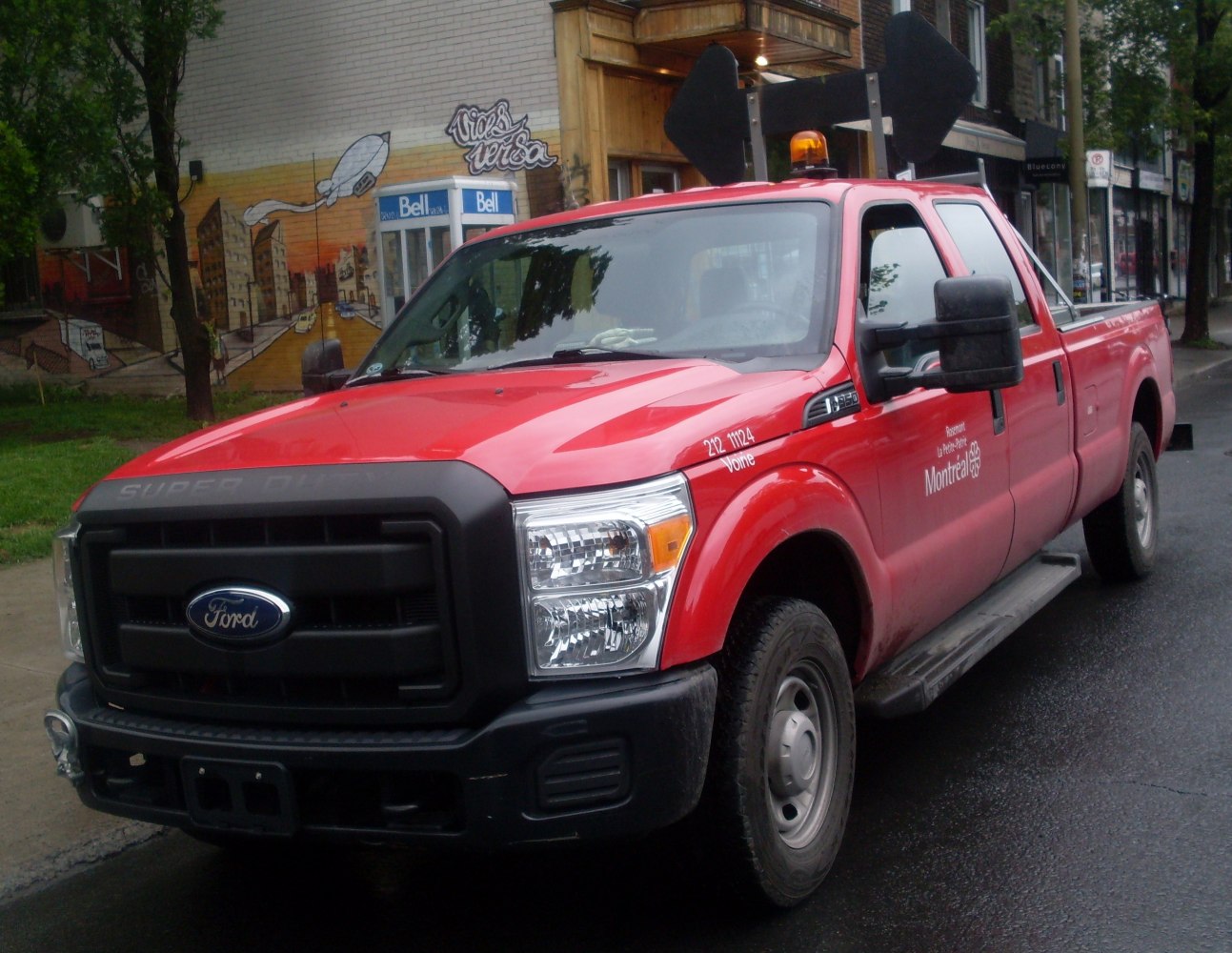 Red heavy-duty pickup with large black grille and amber warning light
