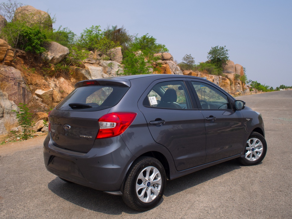 Rear side profile of a compact hatchback with alloy wheels and rear spoiler