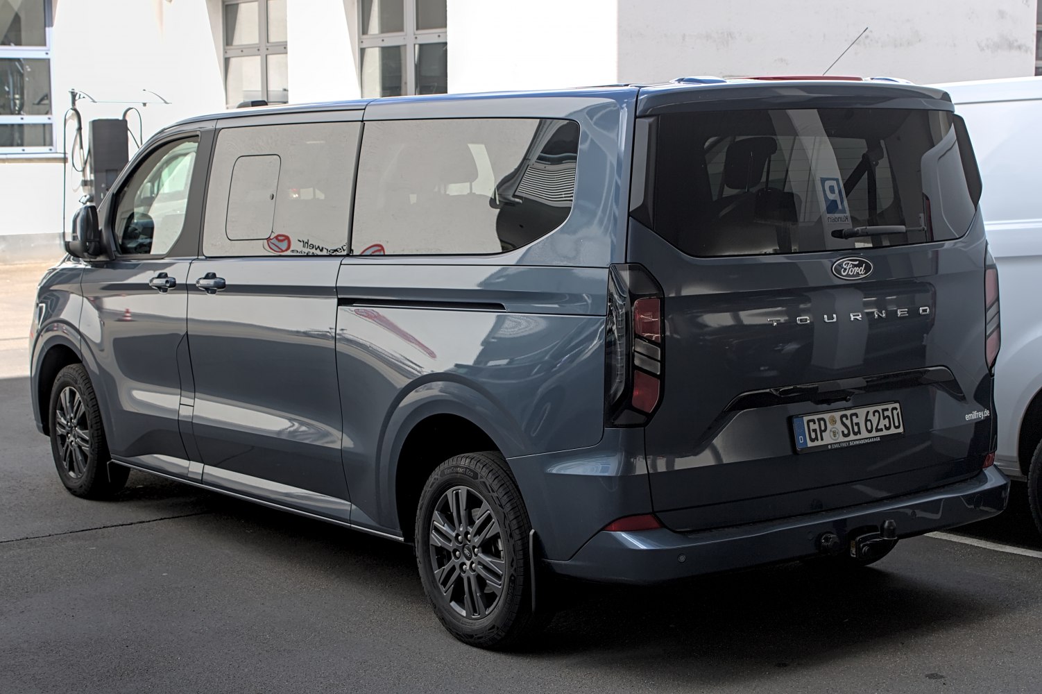 Rear and side profile of a dark blue multi-purpose van with tinted windows and modern tail lights