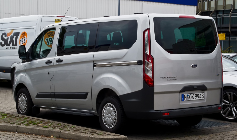Silver passenger van rear side with sliding door and tinted windows