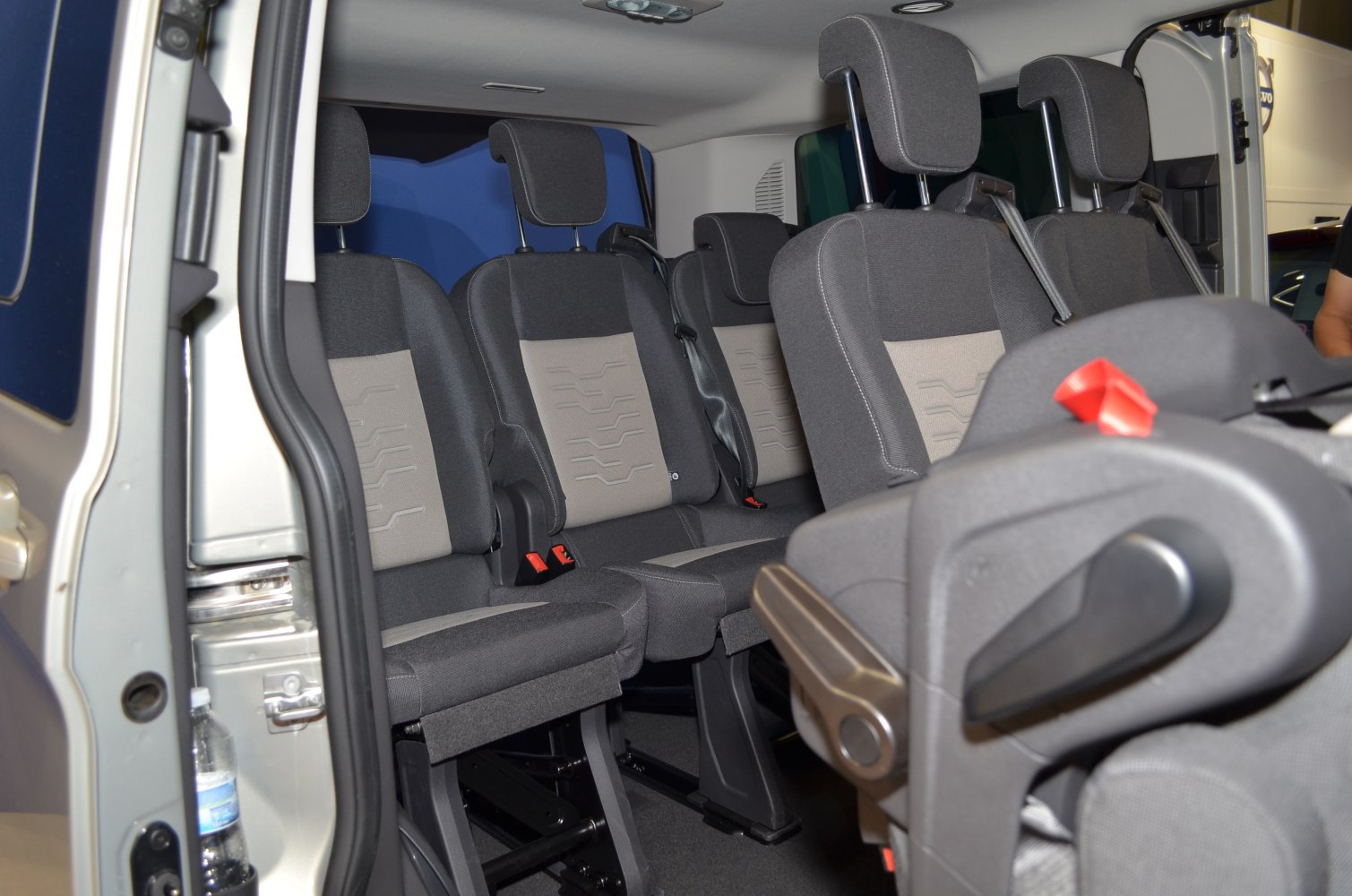 Multi-row passenger seating with adjustable headrests and seat belts