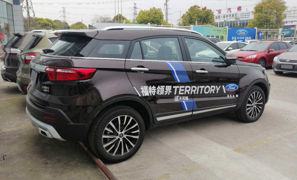 Black SUV with blue racing stripe and bold side decals in parking lot