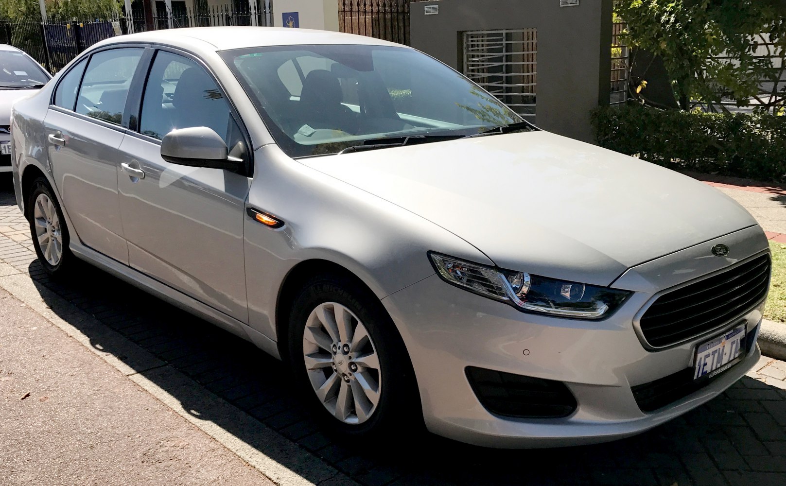 Silver sedan front and side with headlights, grille, alloy wheels