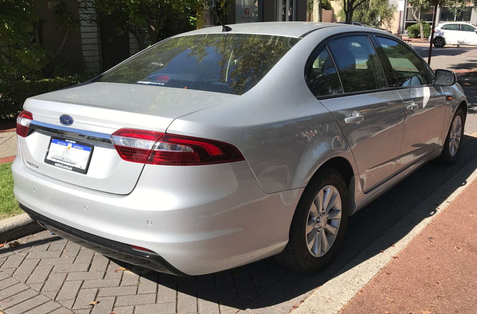 Silver sedan rear side with taillights and alloy wheels